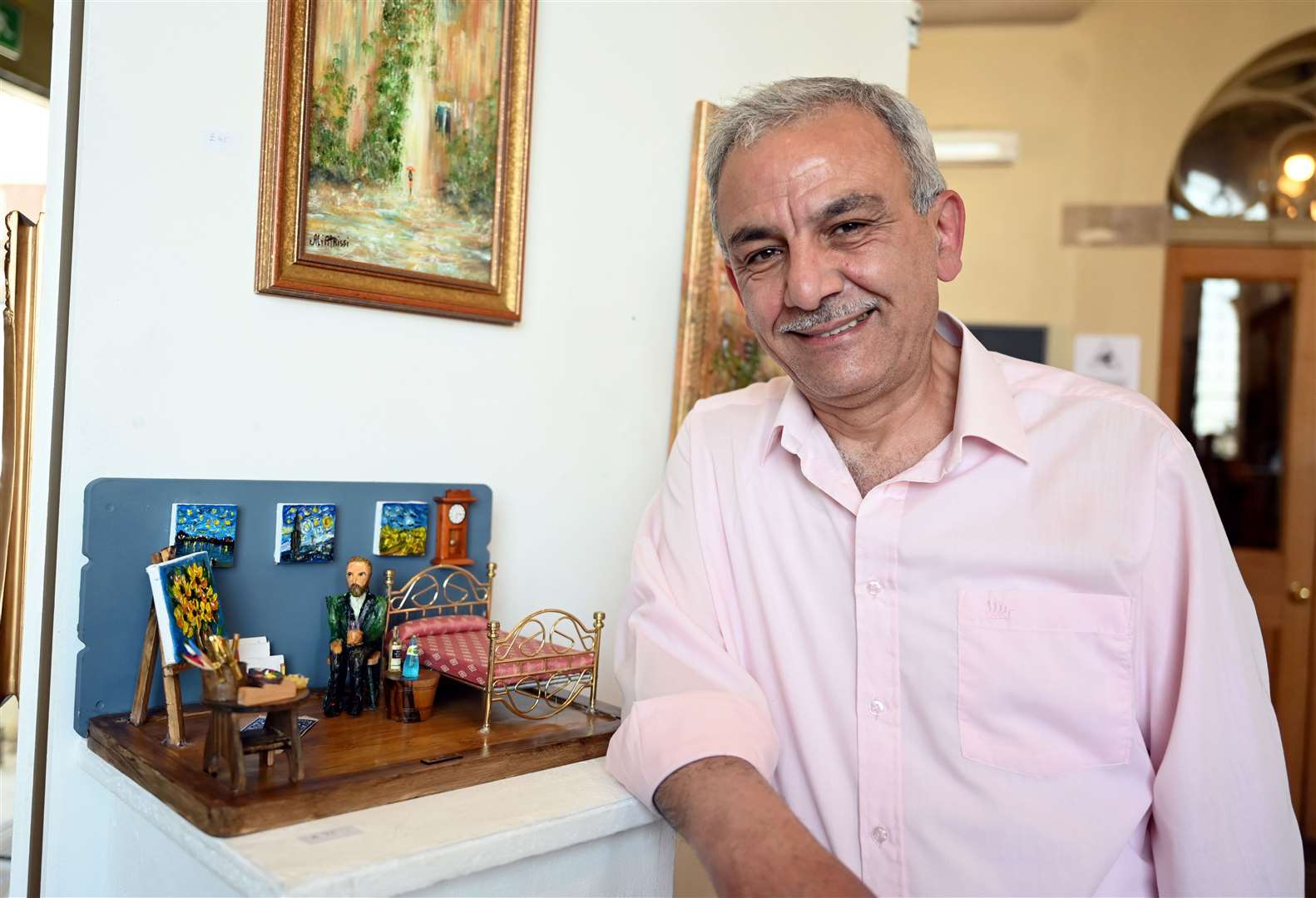 Ali Atrissi with his miniature model and paintings