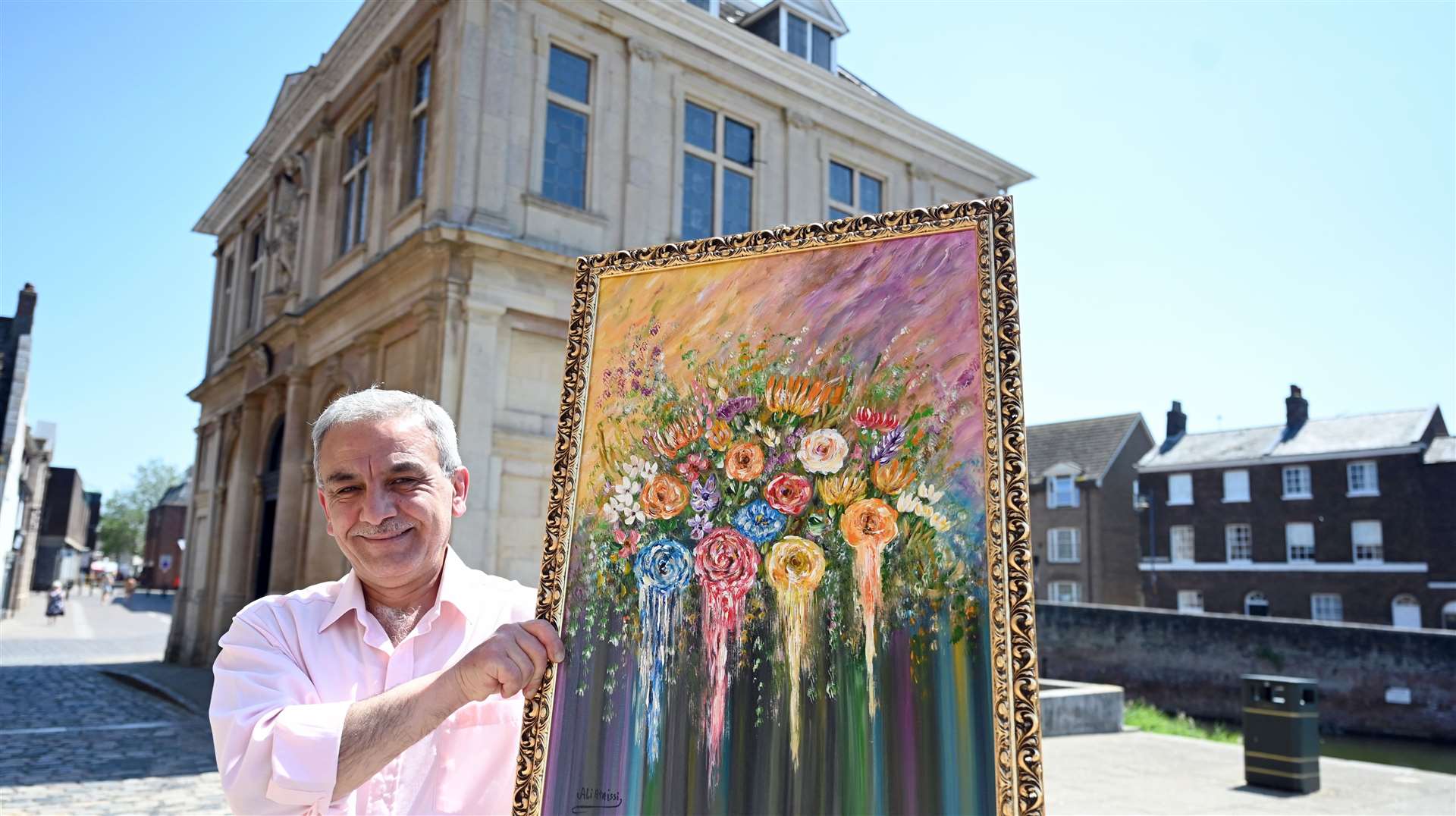 Ali with one of his artworks outside the Custom House, where his exhibition is being held