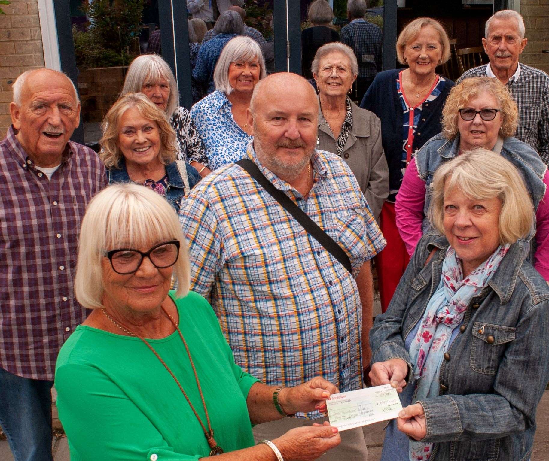 Family and friends watch on as Jeanette Stapleton of the Parkinson’s group receives a cheque from Patsy Ashwood