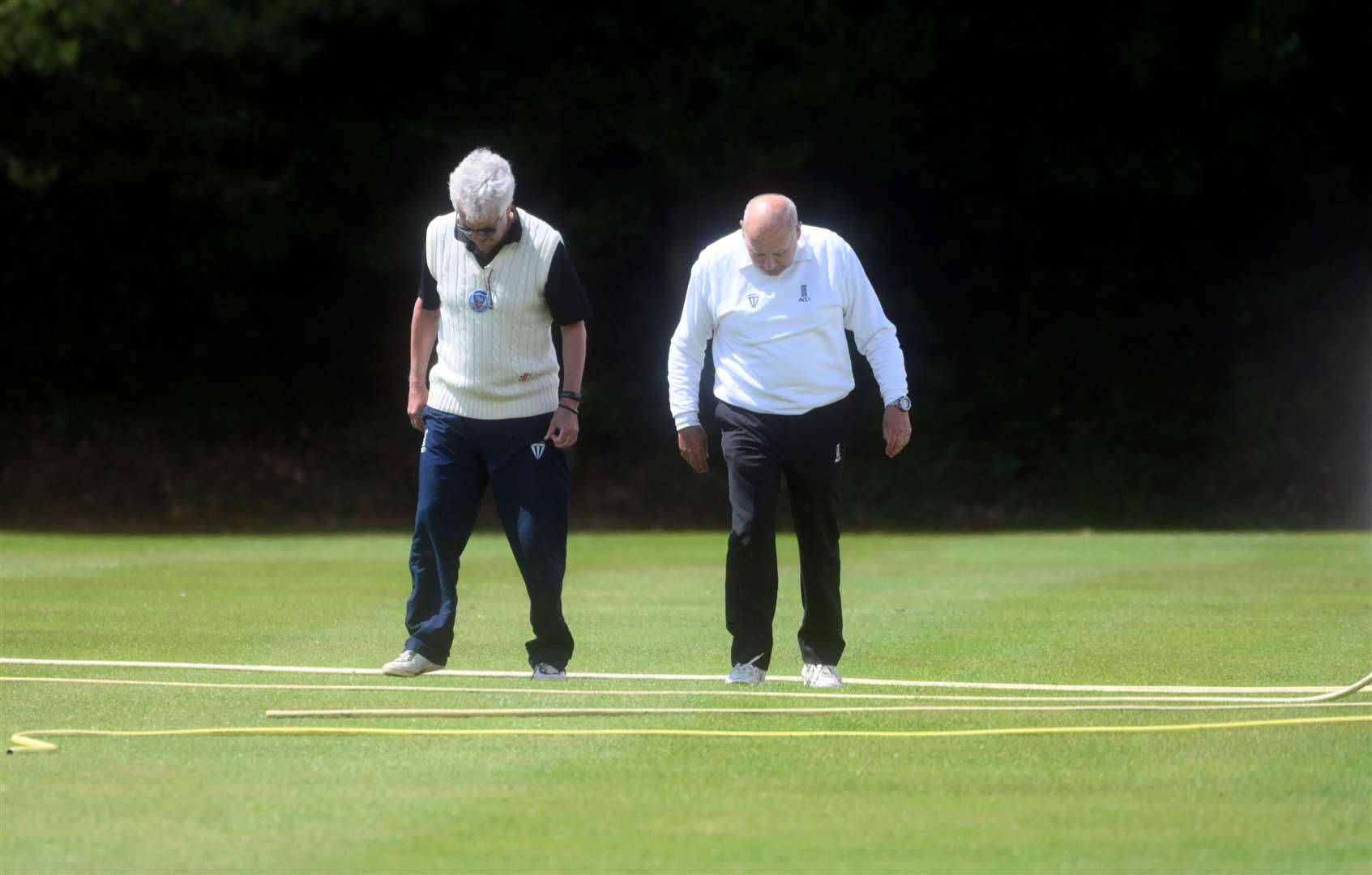 The umpires take a look at the wicket after rain delayed the start of North Runcton's Norfolk Alliance Premier Division game against Fakenham on Saturday.
