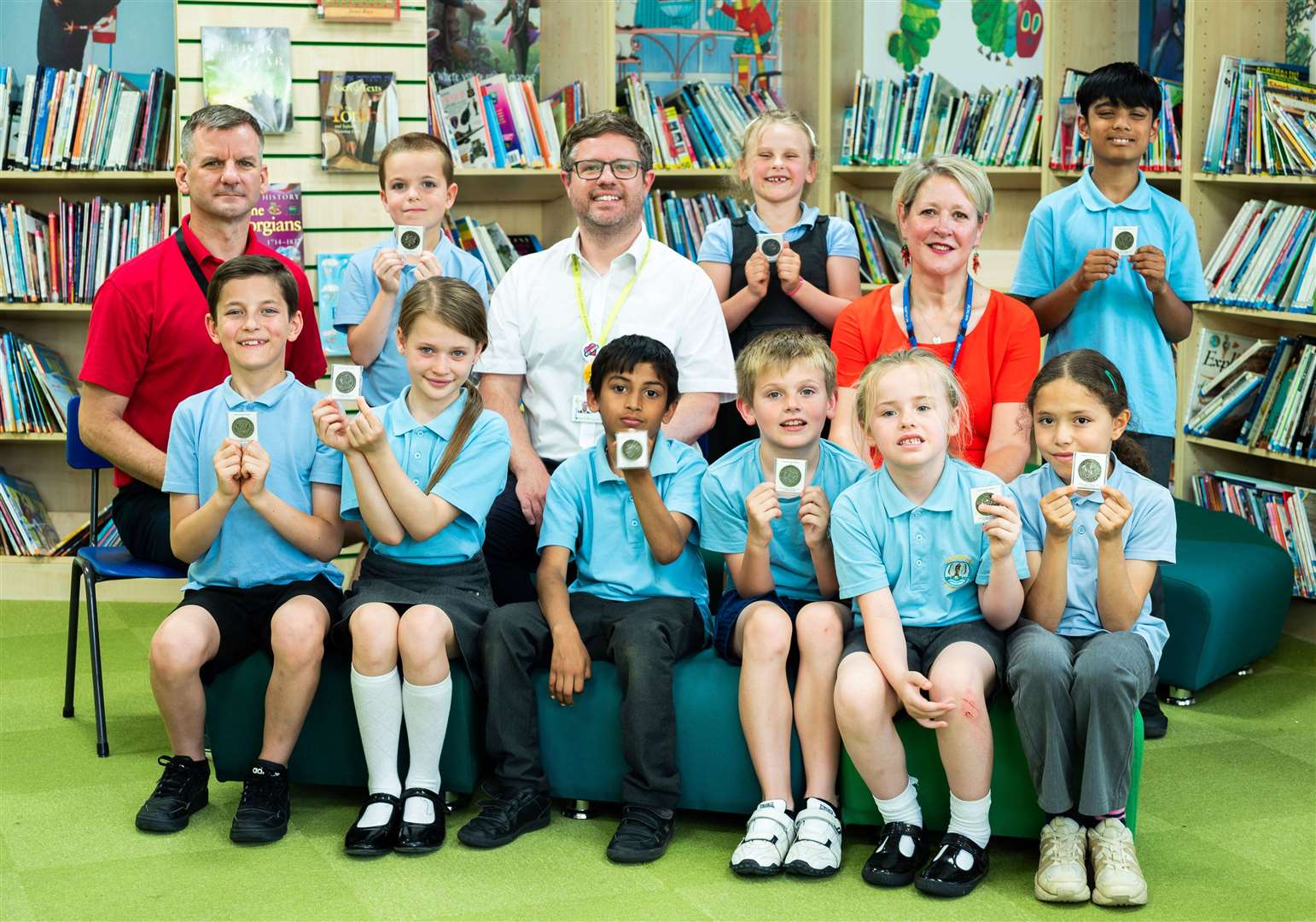 Councillors Rob Colwell and Jo Rust with pupils at Gaywood Primary School, proudly holding their Coronation coins