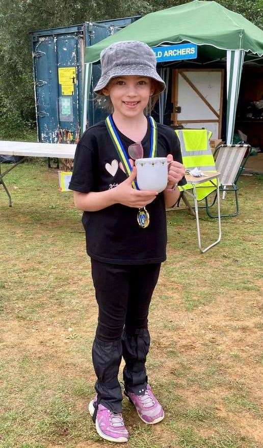 Ellie Murphy showing off her medal and cup (Picture: King's Lynn Archery Club)