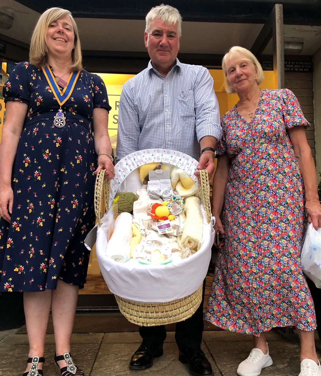 Rotary President, Mel Robson, Chairman of the community committee, Ian Mason, (holding a Moses basket which was to be taken to the QEH the following day), and Maggie Anderson from Baby Basics.