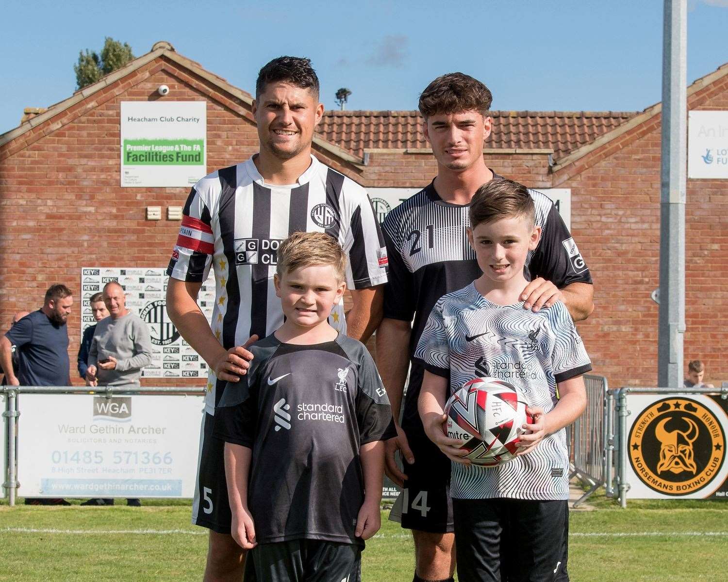 Heacham ascots for their FA Vase game against Dussindale were Freddie and Will Noble. Freddie and Will are pictured with Matt Goss, captain for the day, and favourite Magpies’ player Jack Noble. Picture: Phill Gwilliam