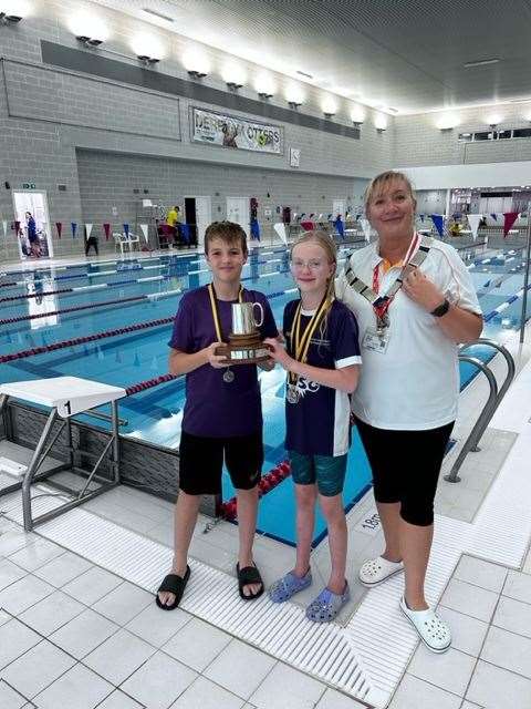 Cory Hill and Nellie Chadderton collect the award for Top Club on behalf of West Norfolk Swimming Club from President of Swim England Norfolk Cheryl Rose.