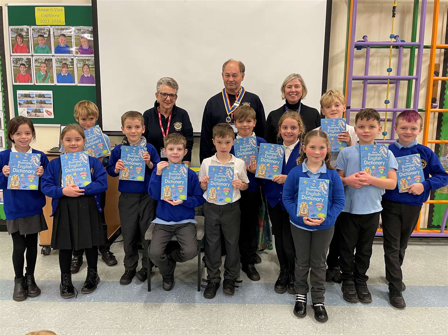 Priory President Paul Batterham and Elizabeth Eagling with Head Teacher Jennie Wildsmith-Garton presenting the dictionaries to the Year 4 pupils