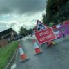 Burst water main results in closure of busy road into villages