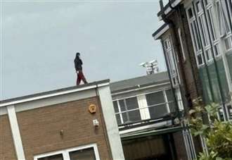 Police rush to scene as masked teenager is spotted on school roof