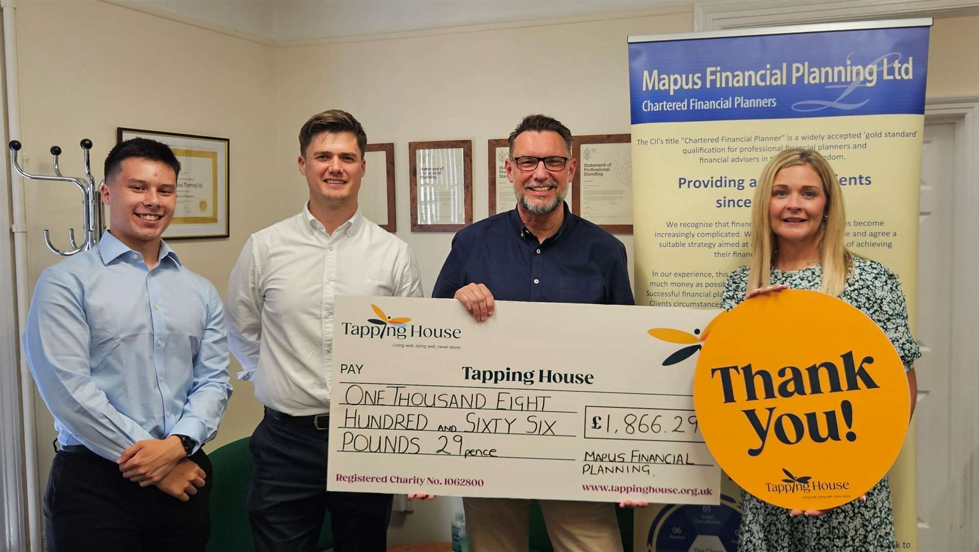 Lindsey Atkin of the Tapping House receiving the cheque from the director, Robin Williams, alongside two of the runners.