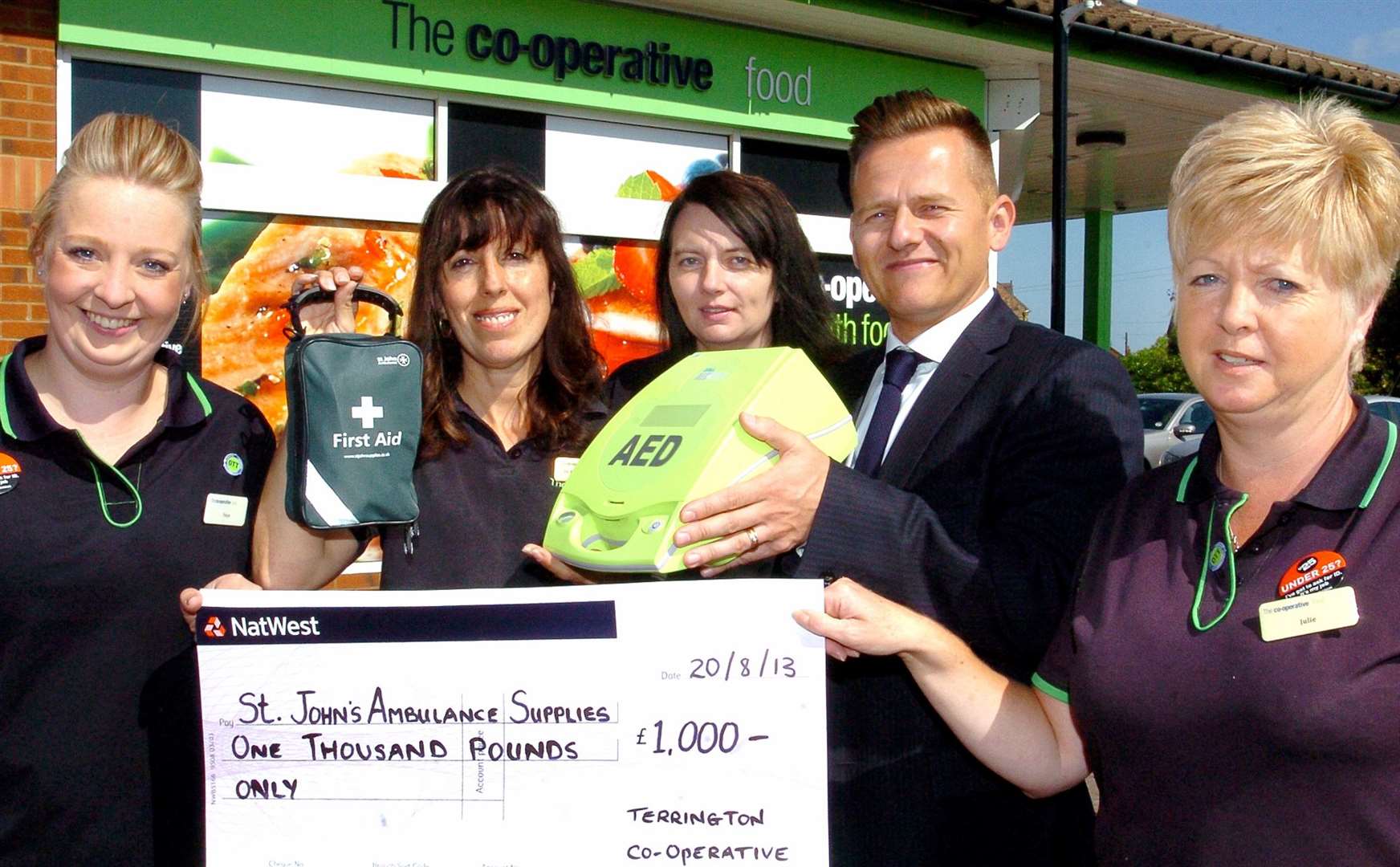 Staff at the Co-Operative Food Store in Terrington St Clement with the new AED, along with the £1,000 cheque to pay for the equipment, from left: Faye Poynter, Jo Butler-Eldridge (duty manager), Steph Dye (duty manager), Jamie Heywood (National Accounts Executive St John Ambulance), Julie High