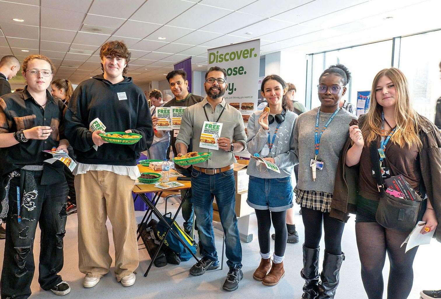 Students with Subway staff at a Freshers' Fair stall