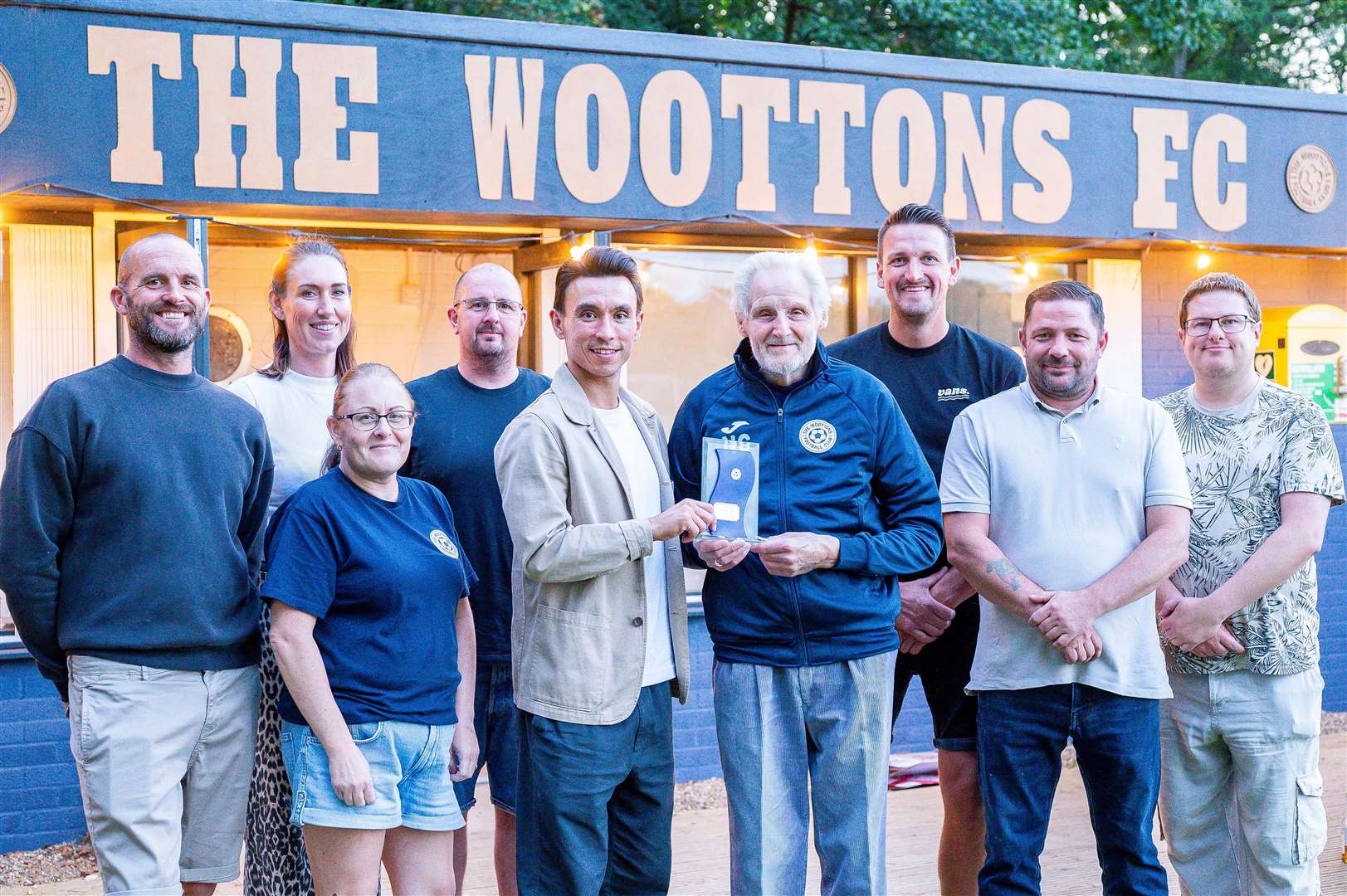 Pictured, from left, is The Woottons club president Tim Kirby, welfare officer Jen Rudd, clubhouse manager Lou Gotsell, treasurer Neil Gotsell, King's Lynn Town FC captain Michael Clunan, Norman Cesar, chairman Tom Rudd, vice-chairman Darren Chilvers and secretary Ashley Dickerson.