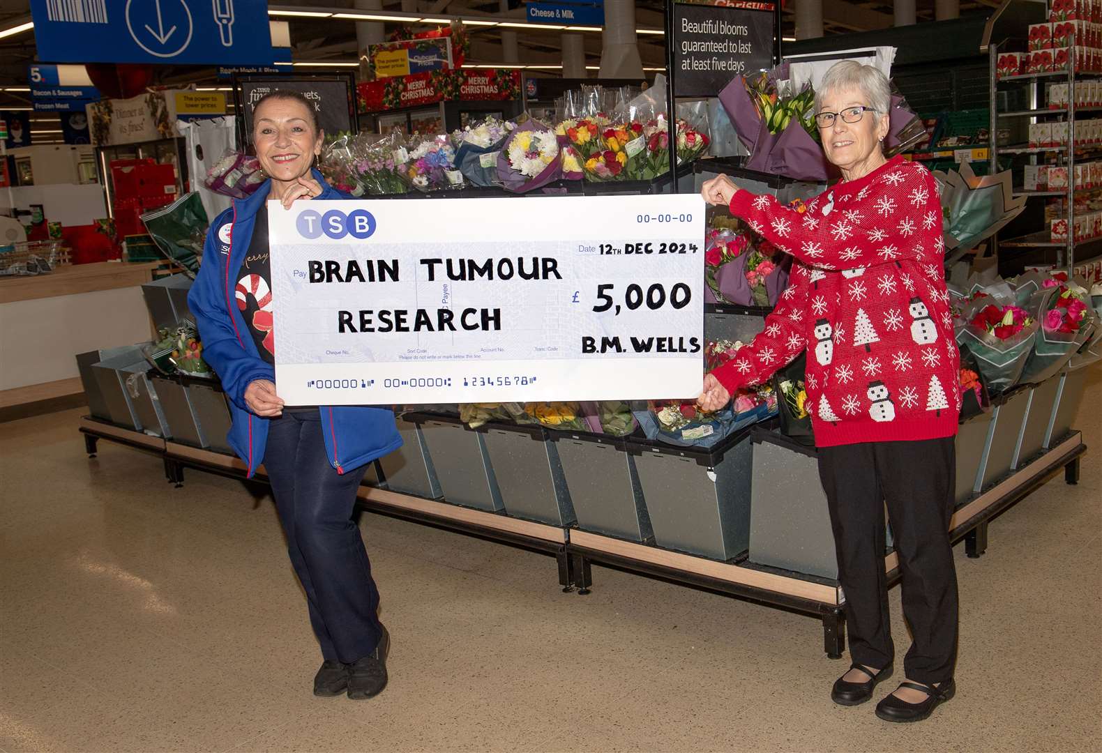 Bridget Wells, right, presents a cheque - which is £5,000 to Brain Tumour Research
